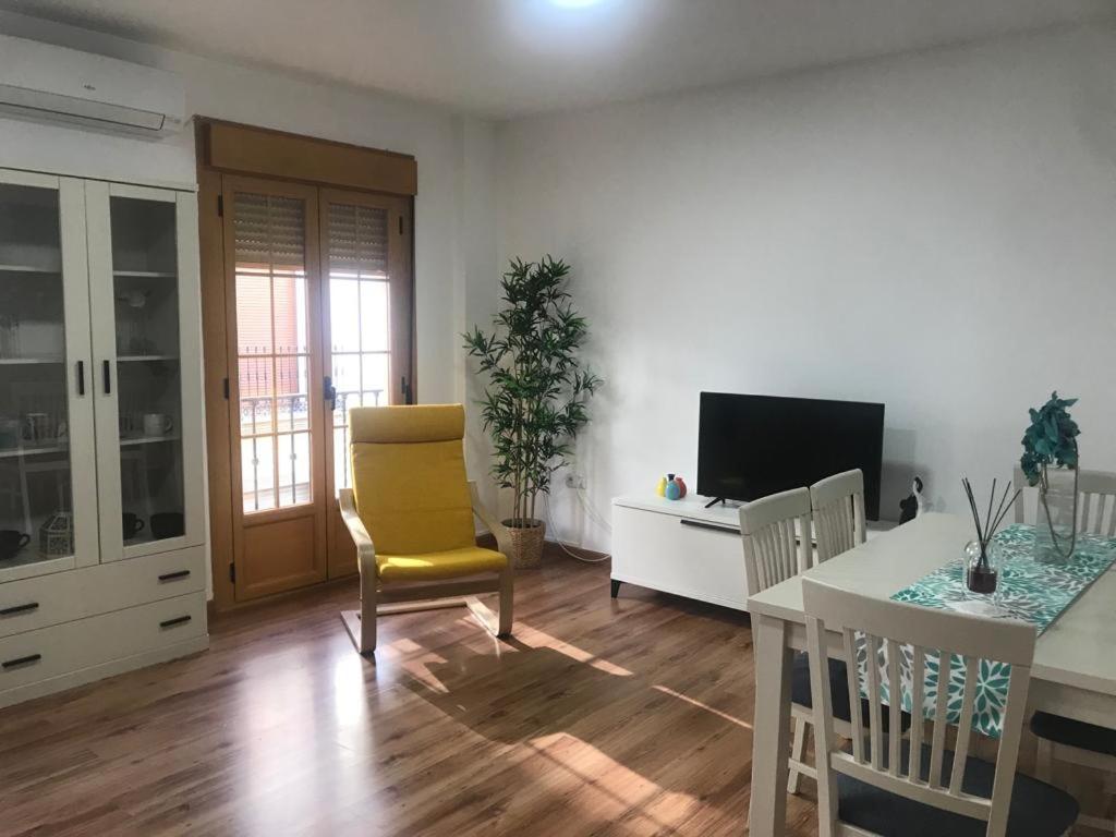 sala de estar con mesa y silla amarilla en Fleur de Lis apartament, en Huéscar