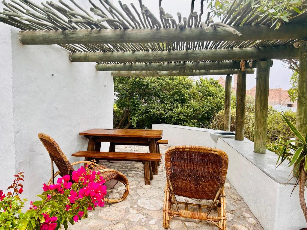 a patio with a table and chairs and flowers at Stay at Bokkoms in Paternoster Self Catering Accommodation in Paternoster