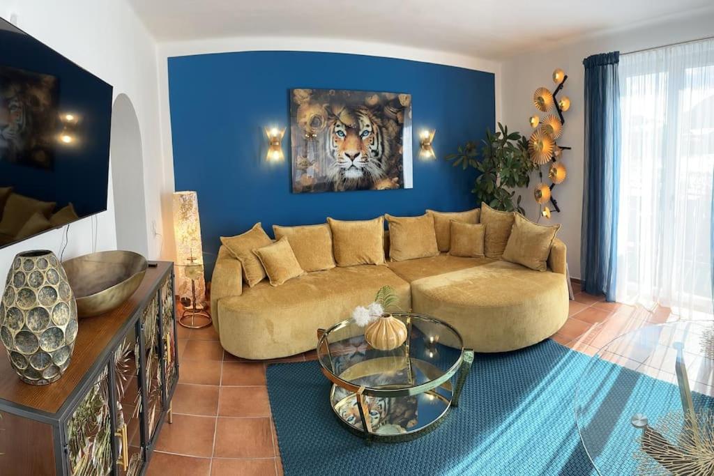 uma sala de estar com um sofá e uma parede azul em Haus Schmidhuber Wohnung 3 em Grossgmain