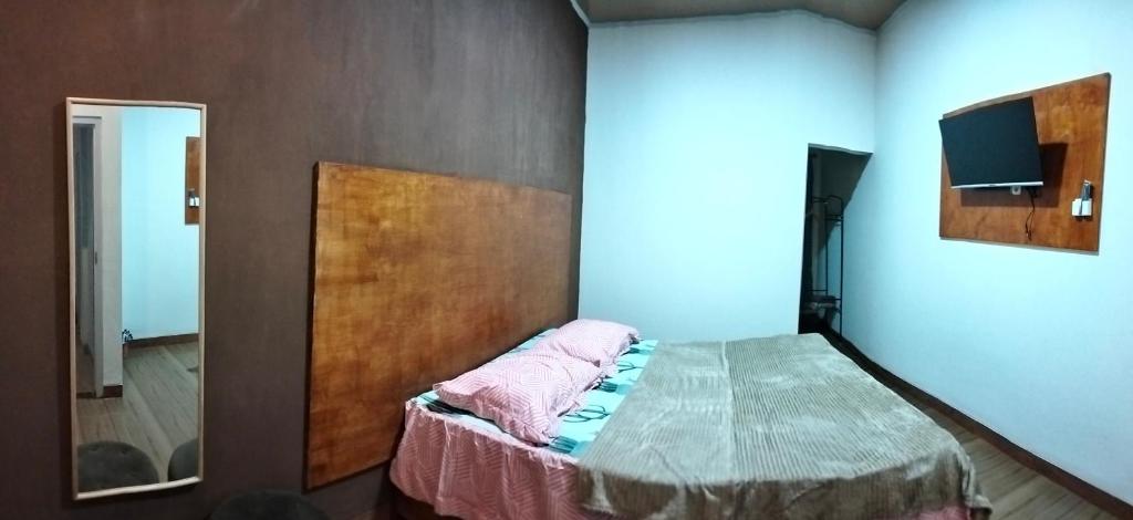Schlafzimmer mit einem Bett und einem Spiegel in der Unterkunft Resy home syariah dekat alun2 wonosobo in Kalianget