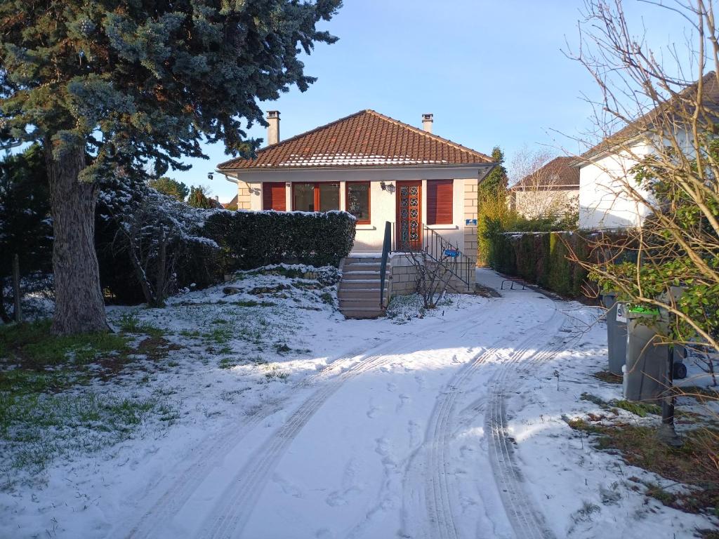 a house with a snow covered driveway in front of a house at la coccinelle in Conflans-Sainte-Honorine