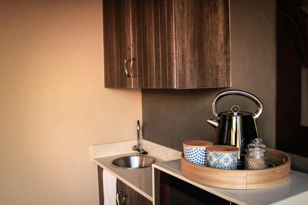 a kitchen counter with a tea kettle and dishes on it at C-Vu-Cottage cosy and warm private apartment in Mossel Bay