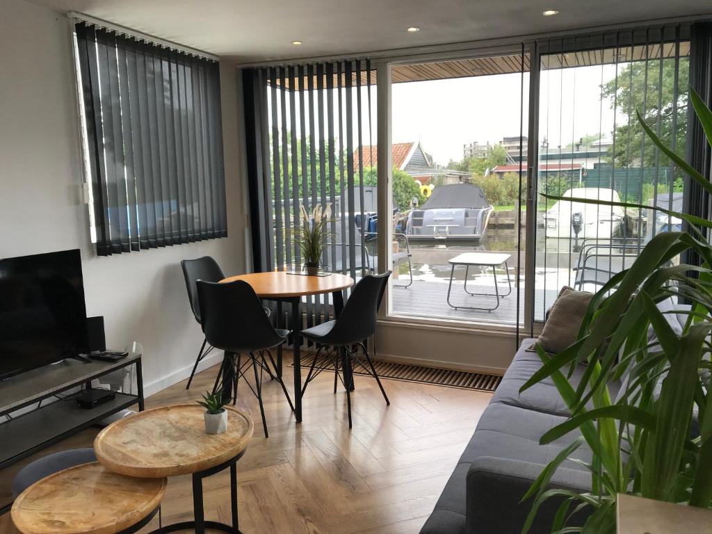 een woonkamer met een bank en een tafel bij Quiet Waterloft near Amsterdam and Schiphol WS11 in Aalsmeer