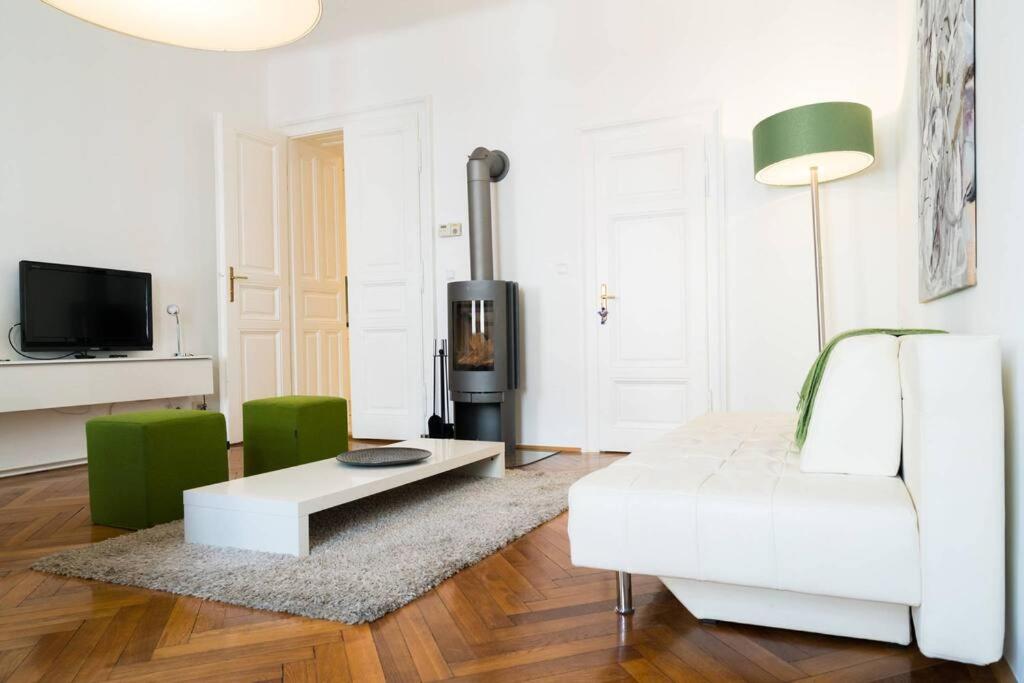 ein Wohnzimmer mit einem weißen Sofa und einem Tisch in der Unterkunft Vienna Residence, Gumpendorfer Straße - Mariahilf #527 in Wien
