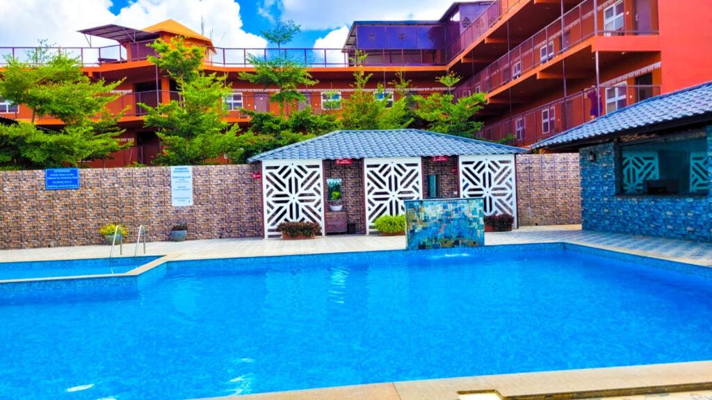 een zwembad voor een gebouw bij Vistar Resort & Hotels in Bangalore