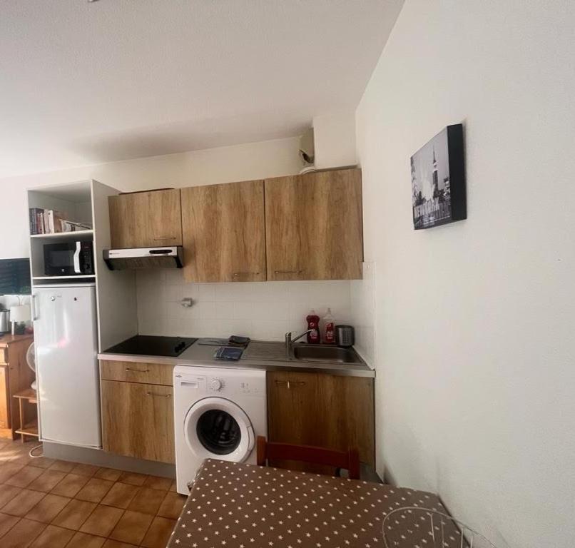 a kitchen with a washing machine in a kitchen at Studio agréable de 21m2 in Balaruc-les-Bains