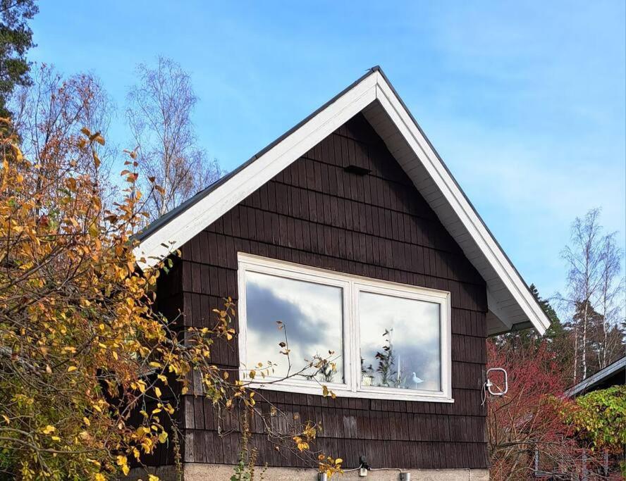 Una casa con una ventana con un gato. en Litet strandnära hus på Adelsö, en Adelsö