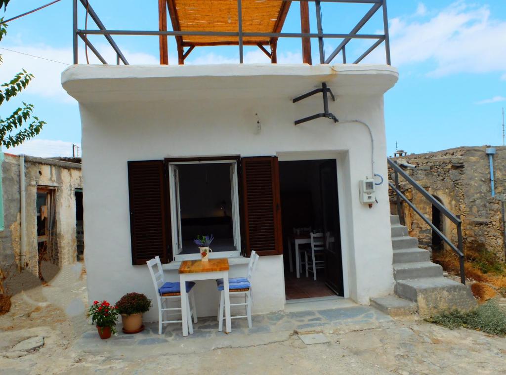 a small white house with a table and chairs at Kavousi Cottages - H Petra in Kavoúsion