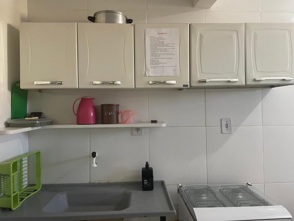 - une cuisine avec des placards blancs et un évier dans l'établissement Apartamento a 1 km da Orla de Atalaia, à Aracaju