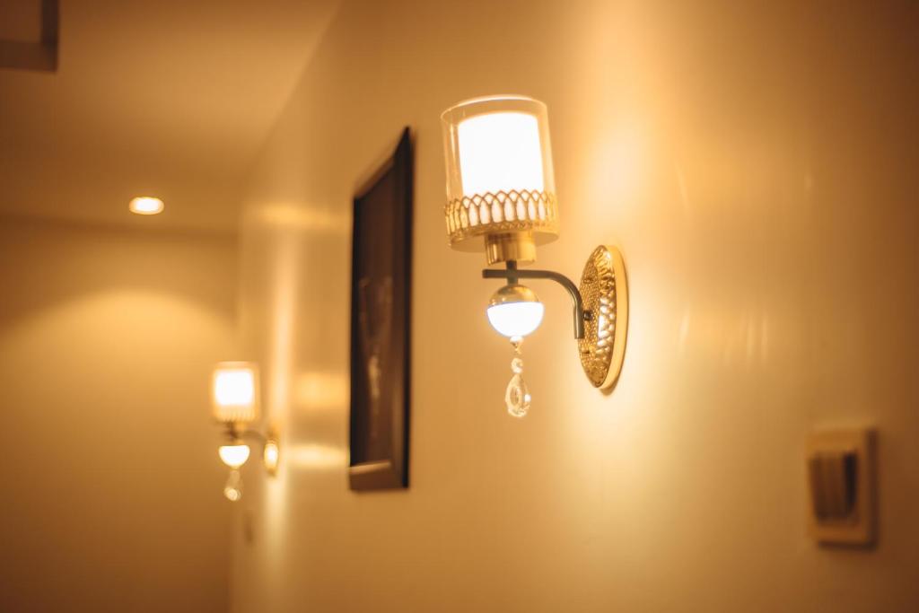 światło na ścianie z lustrem w obiekcie Hols Apartments w Kadunie