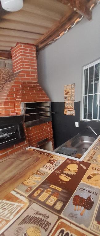 uma cozinha com forno de tijolo e pizzas no chão em Chácara Recanto da Paz em Igaratá