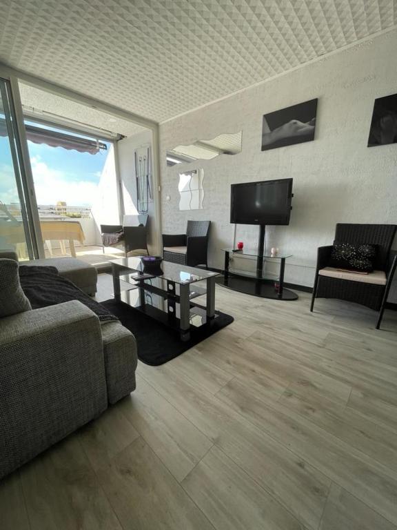 un salon avec un canapé et une télévision à écran plat dans l'établissement Naturiste Cap d'Agde Port Ambonne 304, au Cap d'Agde