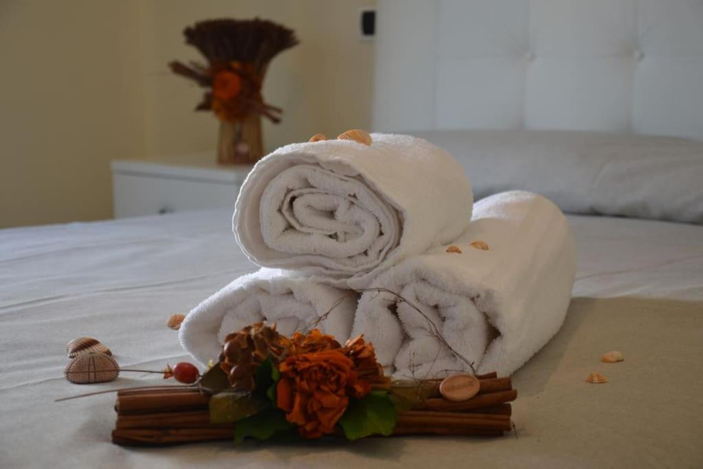een stapel handdoeken bovenop een bed bij Appartamento centrale elegante in Olbia