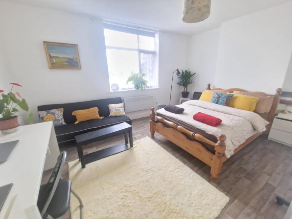 1 dormitorio con 1 cama y 1 sofá en Cosy split-level 2 bed apartment en Leicester