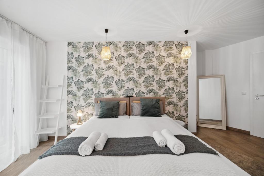 una camera da letto con un grande letto con cuscini bianchi di Sali Homes AM14 großes Apartment mit Terrasse im Zentrum a Bayreuth