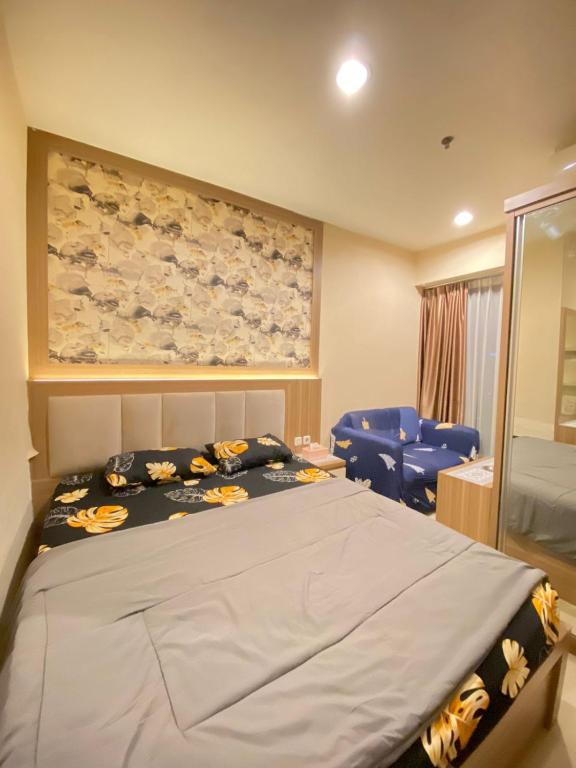 - une chambre avec un grand lit et des chaises bleues dans l'établissement Diamond property, à Bekasi