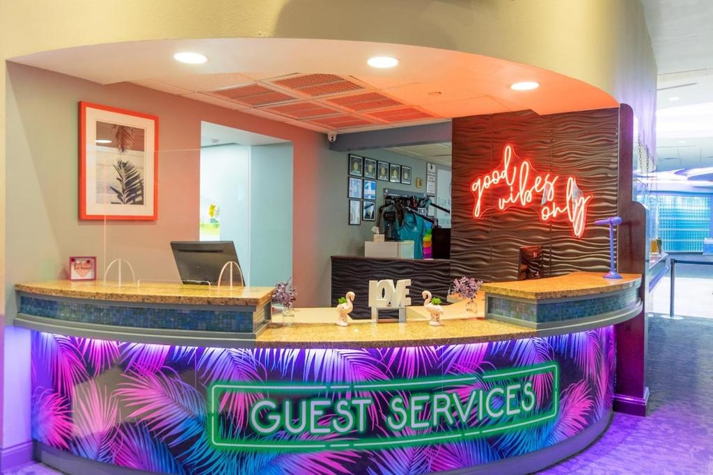 eine Lobby mit einem Gästeservice-Schalter mit Neonschildern in der Unterkunft 1 BR Direct Oceanfront Condo Wyndham Ocean Walk Resort - Daytona Funland 703 in Daytona Beach