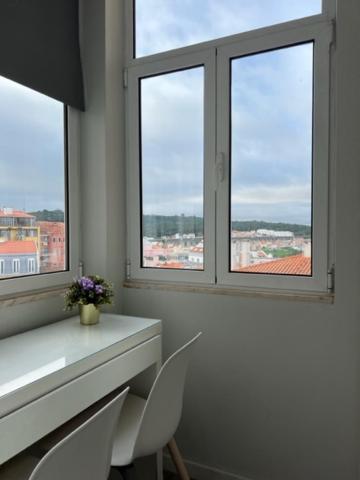 Biały pokój z 2 oknami oraz stołem i krzesłami w obiekcie Lovely Monsanto View Studio Apartment in Campolide - 47 2D w Lizbonie