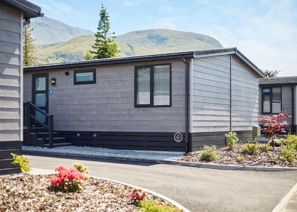 a house with mountains in the background at Ben Nevis Holiday Park in Banavie