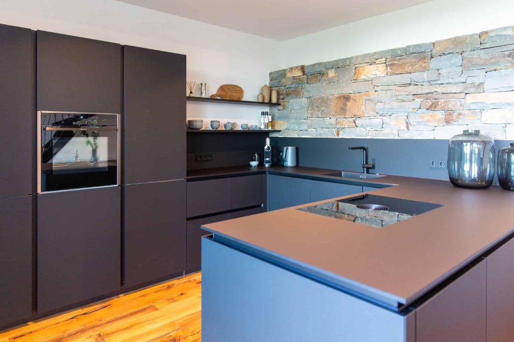 a kitchen with a counter and a stone wall at N6Quartier in Bad Münstereifel