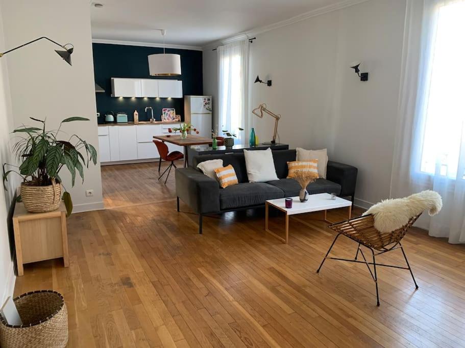 een woonkamer met een bank en een tafel bij appartement moderne et lumineux in Clamart