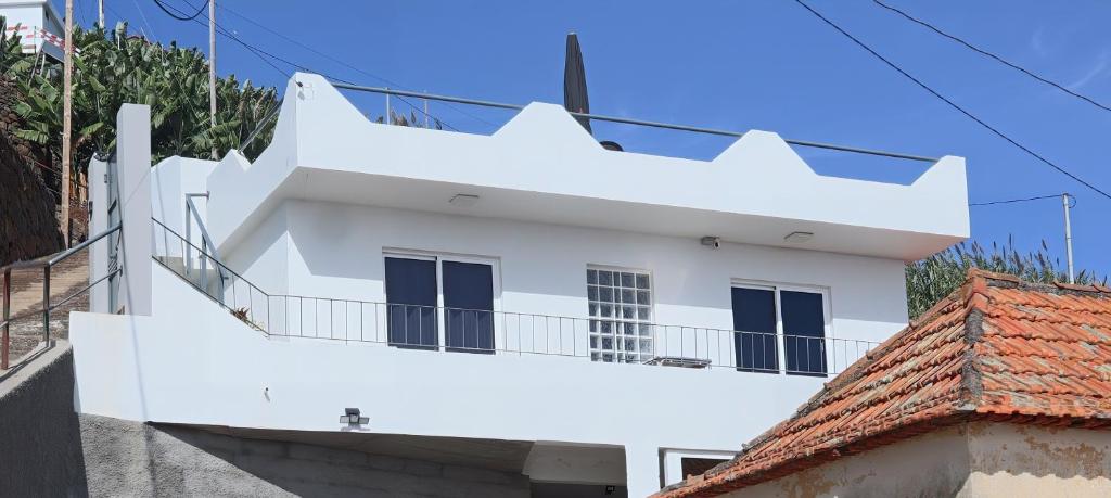een wit gebouw met een balkon erboven bij Fifty´s House in Ribeira Brava