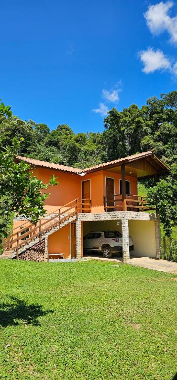 a house with a car parked in front of it at Chalé mirante da colina in Visconde De Maua