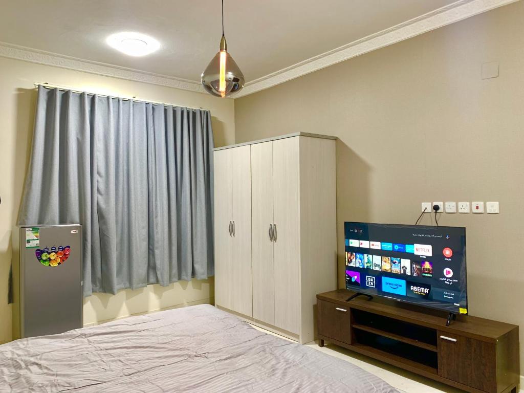 a bedroom with a bed and a flat screen tv at غرفة مزدوجة مدخل خاص دخـول ذاتي Private Room in Riyadh