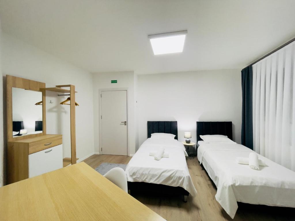 a hotel room with two beds and a table at PristinaNEST in Pristina