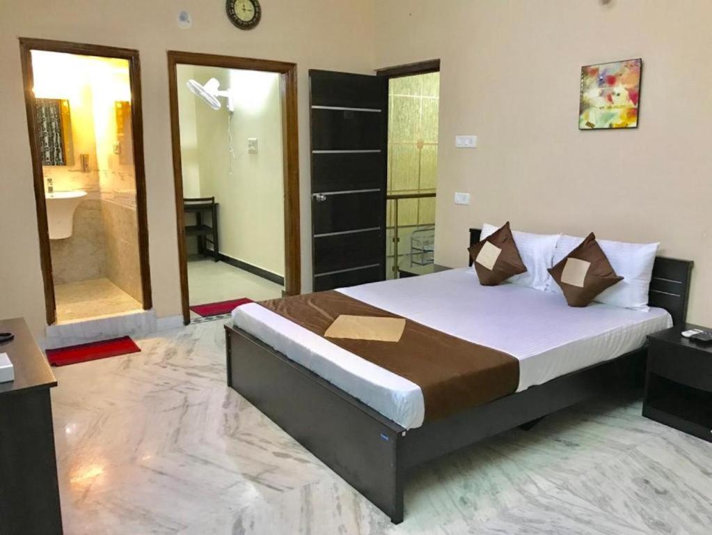 a bedroom with a large bed and a bathroom at Nallur Mylooran Arangam in Jaffna