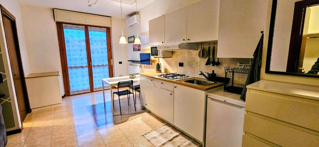 a kitchen with white cabinets and a stove top oven at Sweet Home in Garbagnate Milanese