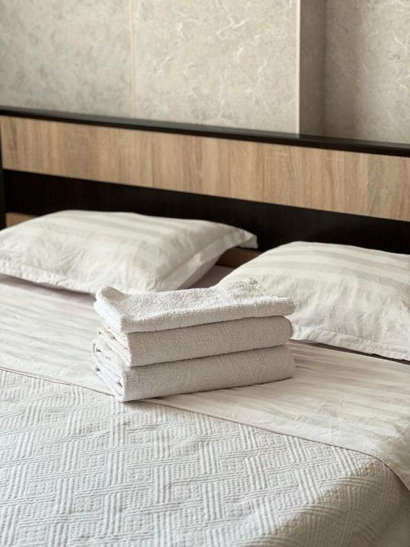 duas toalhas brancas em cima de uma cama em PROMENADE BISHKEK em Bishkek
