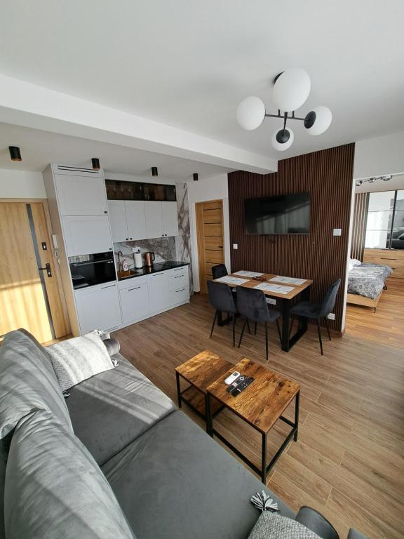 a living room with a couch and a table at Apartament Kluskowe Widoki in Kluszkowce