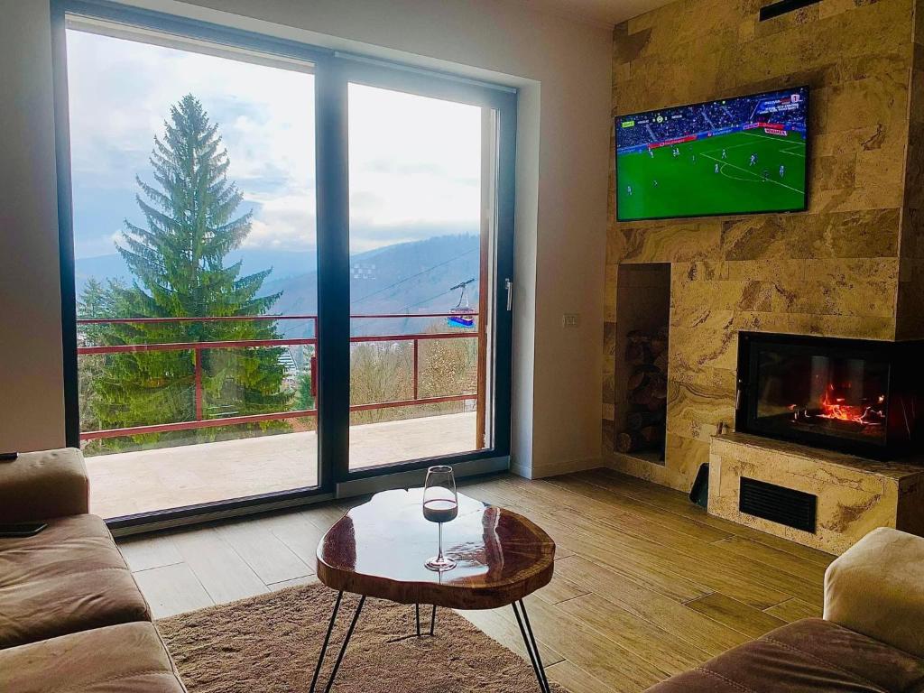 a living room with a large window and a tv at Stone House Sinaia in Sinaia