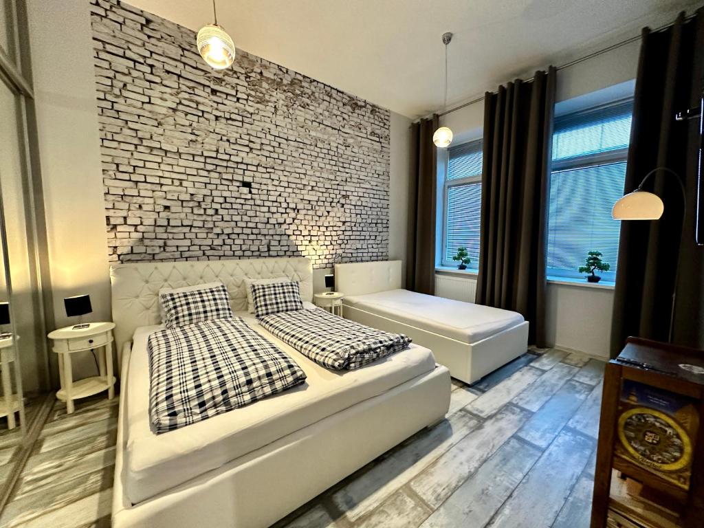 a bedroom with a bed and a brick wall at Royal City Centre Apartment in Poprad