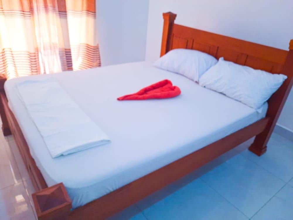 Una cama con una toalla roja encima. en One Bedrooms with 2 Bed Kisimani Heights Apt, en Mombasa