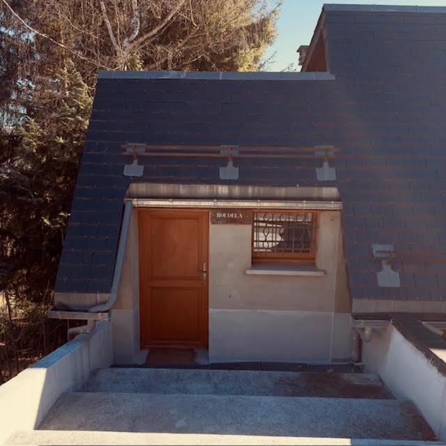 a small building with a brown door and a window at LE NID ROUDELA in Garin