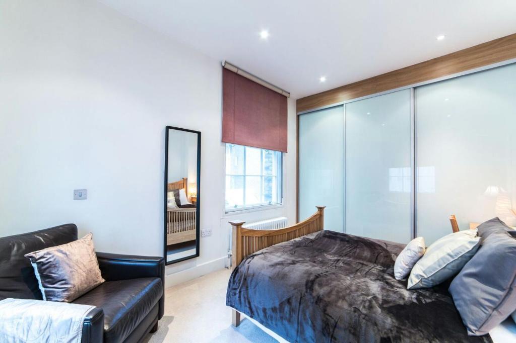 a bedroom with a bed and a couch at StayInn Aldgate East in London