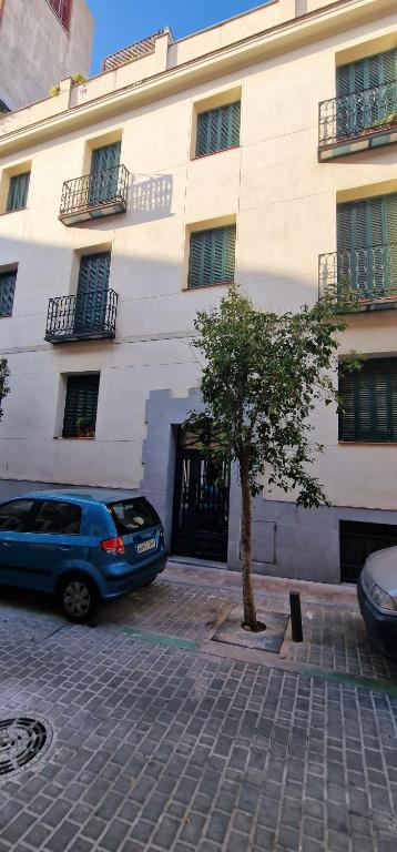 un edificio con un coche aparcado delante de él en Turísticos Cuenca 3, en Madrid