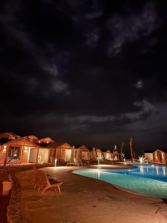 a swimming pool at night with a cloudy sky at Ananda Beach Camp in Nuweiba