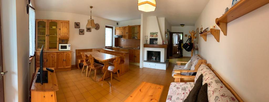 una cucina e una sala da pranzo con tavolo e sedie di CASA GILDA Val di Fiemme - Dolomiti a Cavalese