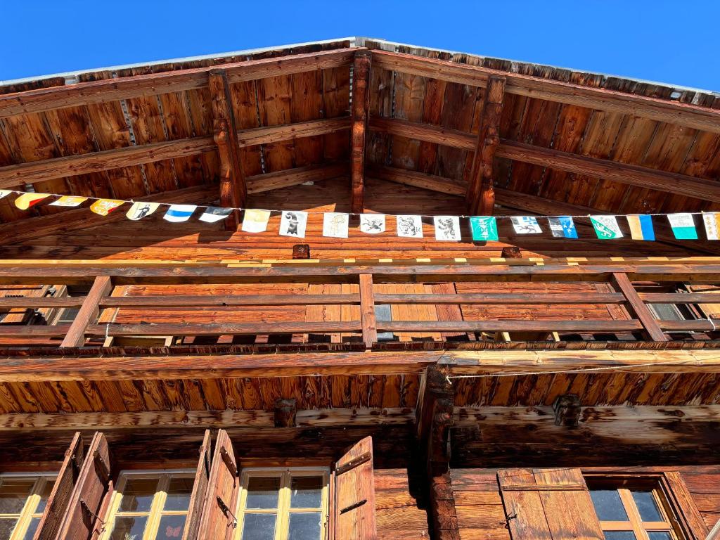 un techo de un edificio de madera con una cadena de banderas en Chalet Plein Soleil - 100% Nature & authenticité, en Vers L'Eglise