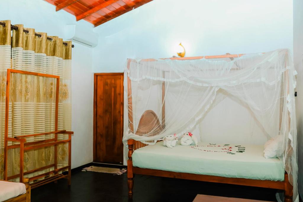 a bedroom with a bed with a canopy at Beach Lagoon Guesthouse in Tangalle