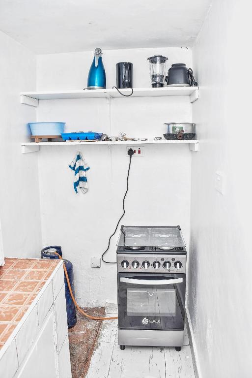 a kitchen with a stove in a white kitchen at Magnolia Apartments in Kisumu