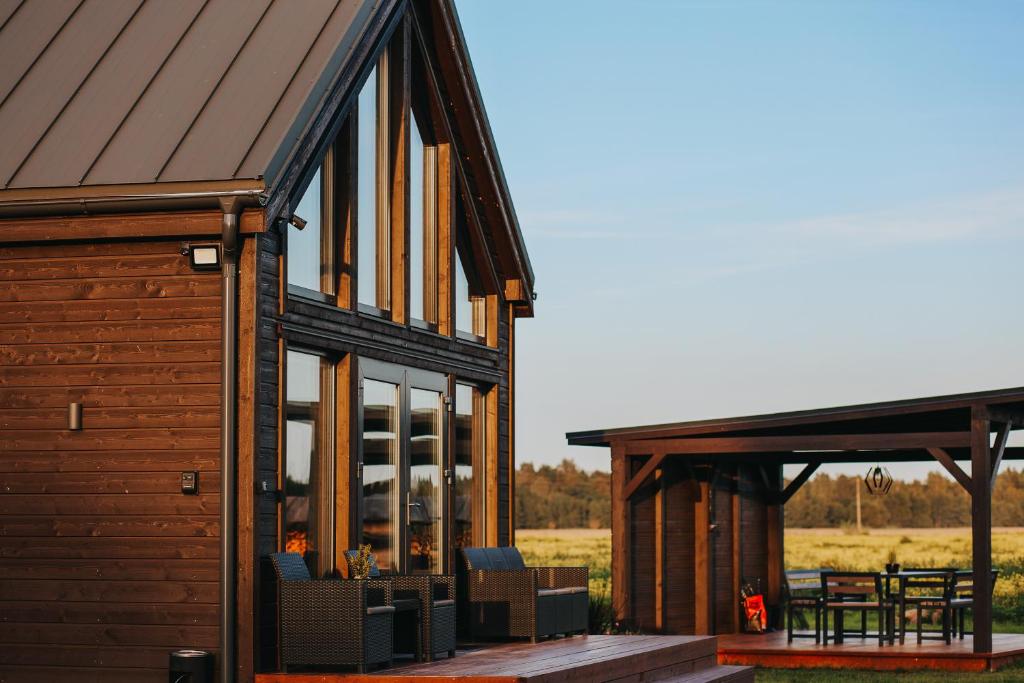 ein Haus mit Glastüren und einem Dach mit Terrasse in der Unterkunft Seashore Holiday House in Saraiķi