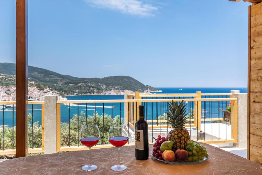 een tafel met twee glazen wijn en een fruitschaal bij Irene's Paradise apartments in Skopelos Town