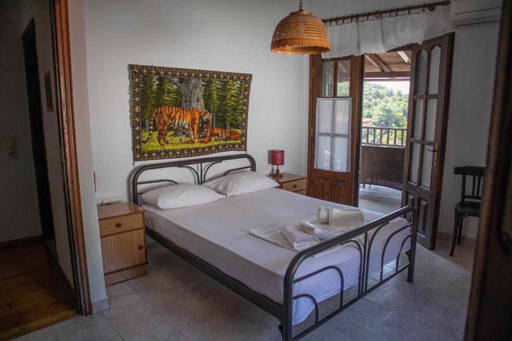 a bedroom with a bed with a painting on the wall at Maries Thasos Stone Villa in Mariaí
