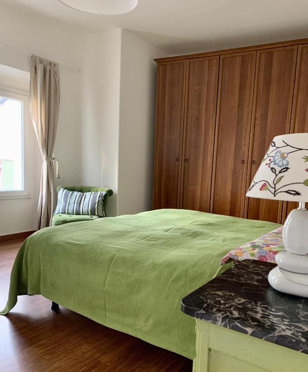 Country Apartament - Malpassuti في Carbonara Scrivia: غرفة نوم بسرير اخضر ونافذة