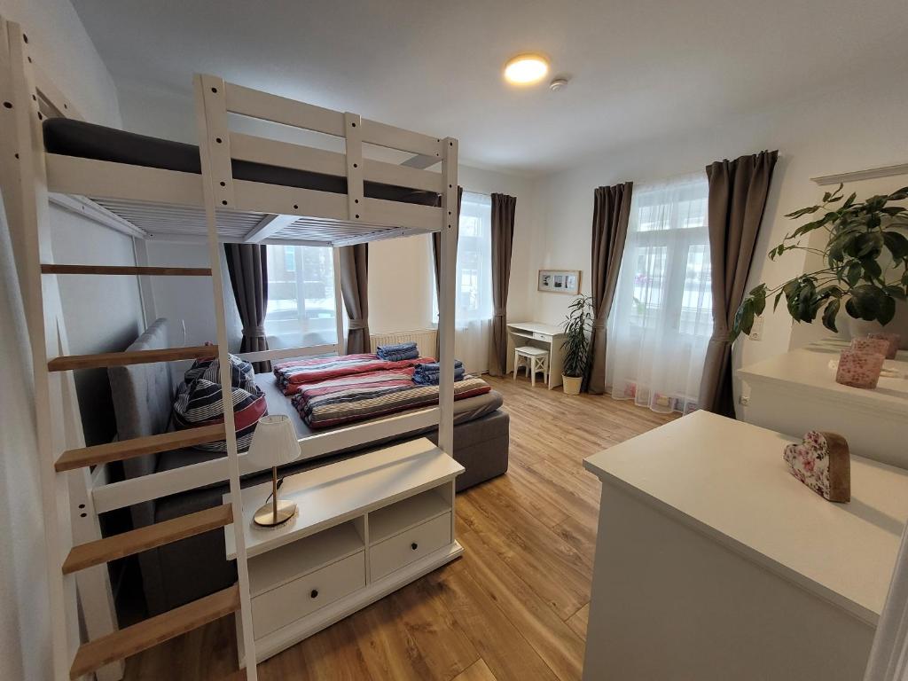 Habitación con litera, escritorio y habitación con cama. en Zum Eulennest, en Dresden