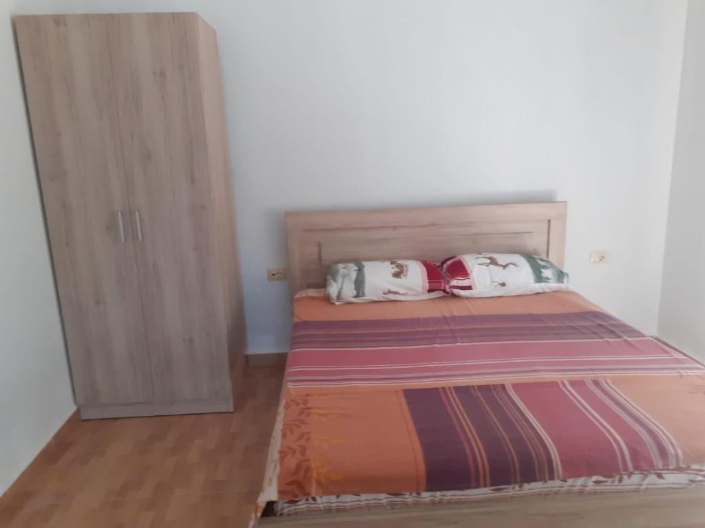 a bedroom with a bed with two pillows on it at Monna Tours in Sarandë